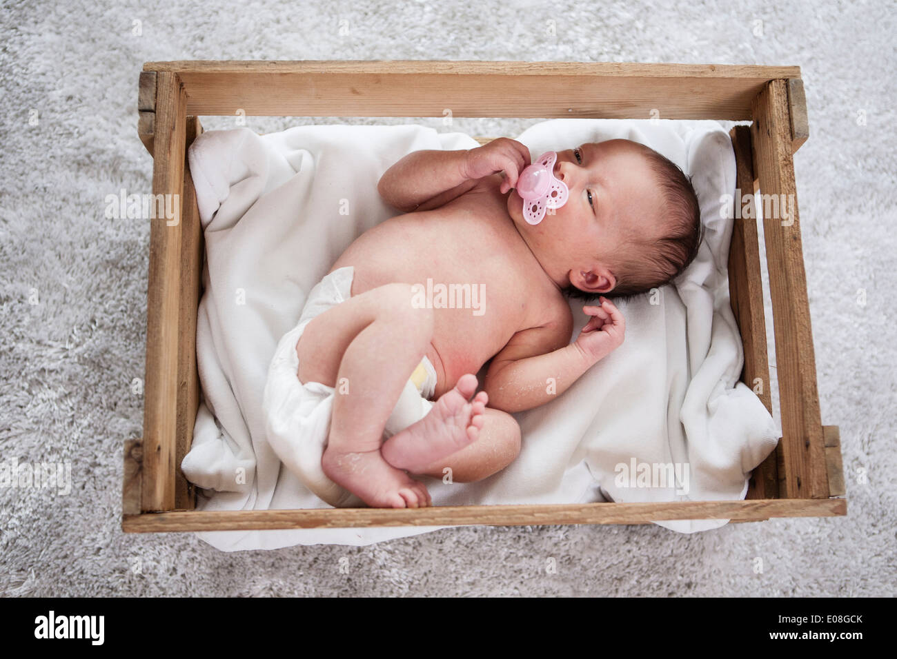 Newborn baby laying asleep with pacifier in mouth Stock Photo