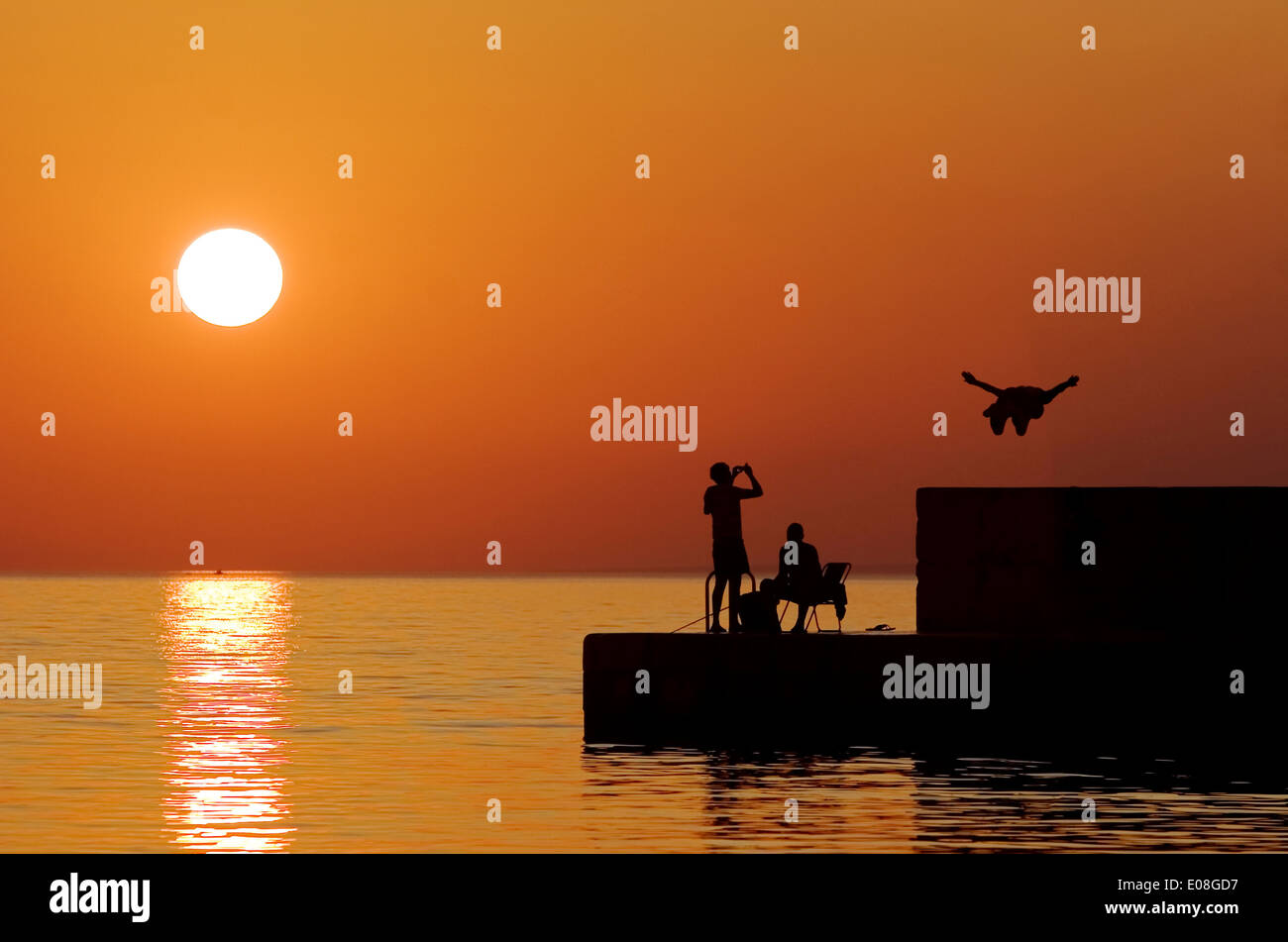 People on the waterfront at sunset, Adriatic Sea, Croatia Stock Photo
