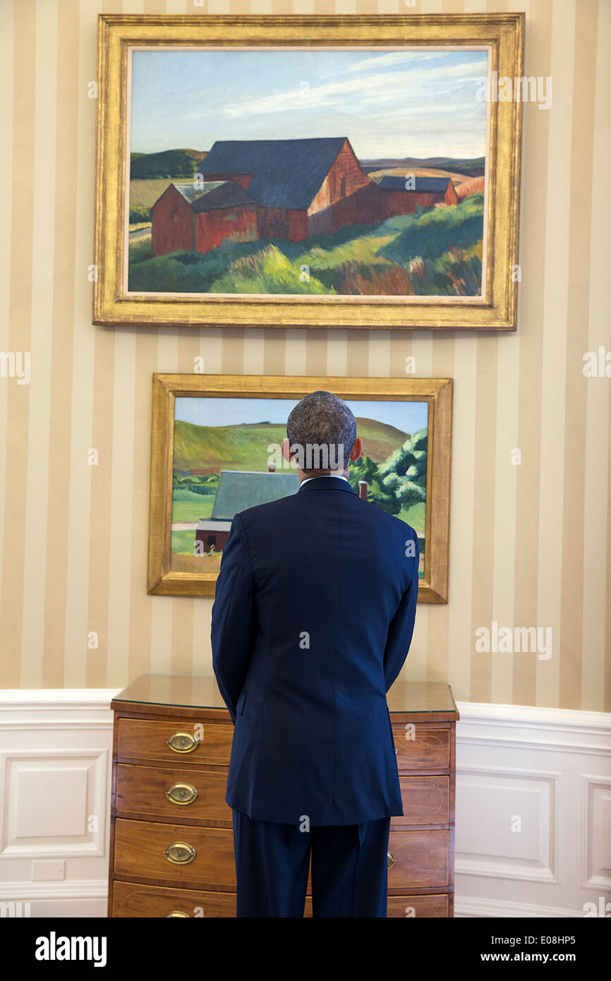 US President Barack Obama views Edward Hopper paintings on display in the Oval Office of the White House February 7, 2014 in Washington, DC. The paintings are Cobb's Barns, South Truro, top, and Burly Cobb’s House, South Truro. Stock Photo