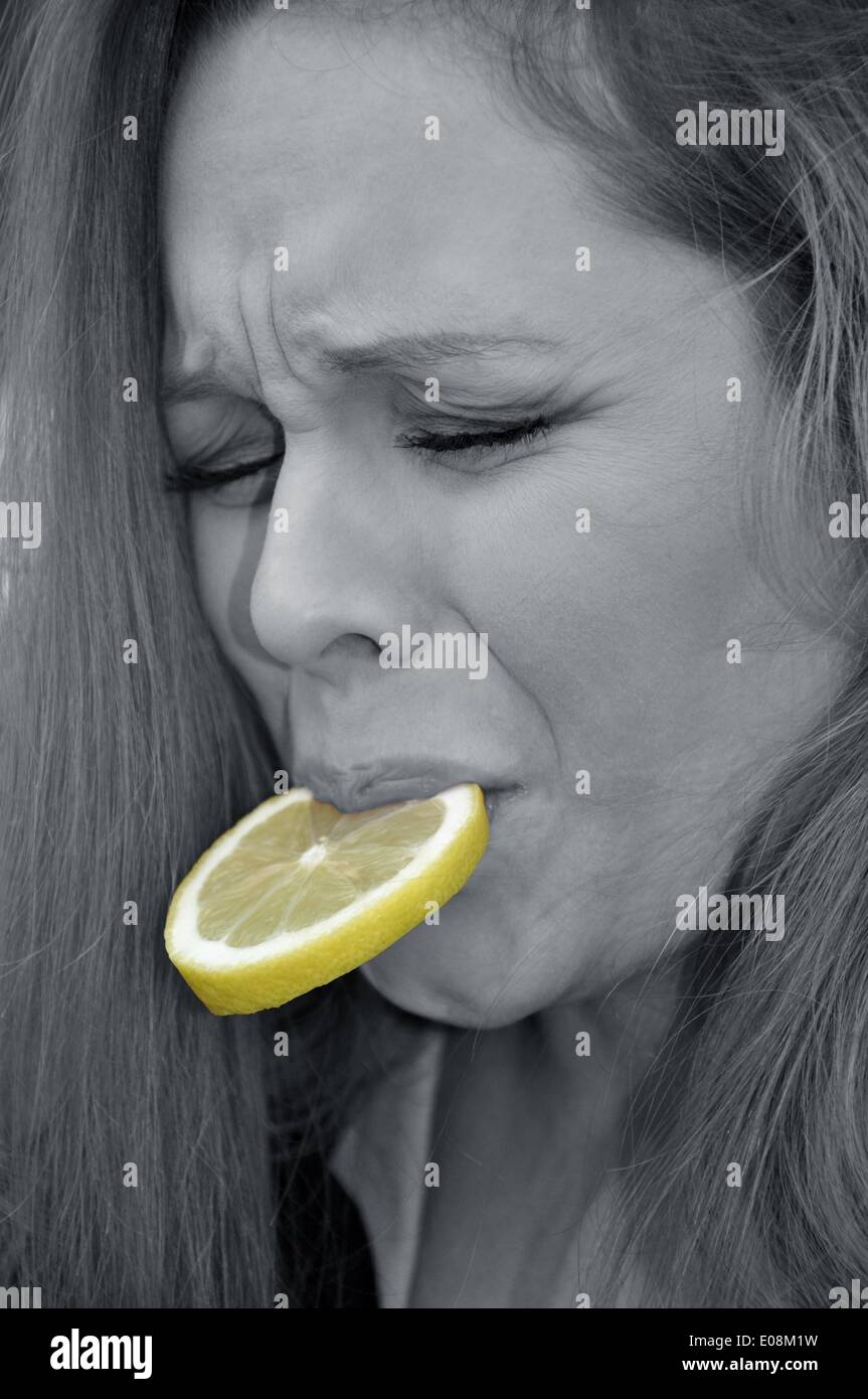 Illustration - A woman grimaces as she bites into a slice of lemon in Germany, 13 January 2013. Fotoarchiv für Zeitgeschichte - NO WIRE SERVICE - Model released Stock Photo