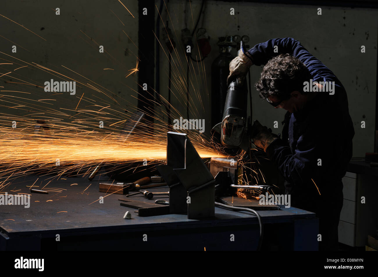 Factory worker using angle grinder to cut metal Stock Photo Alamy