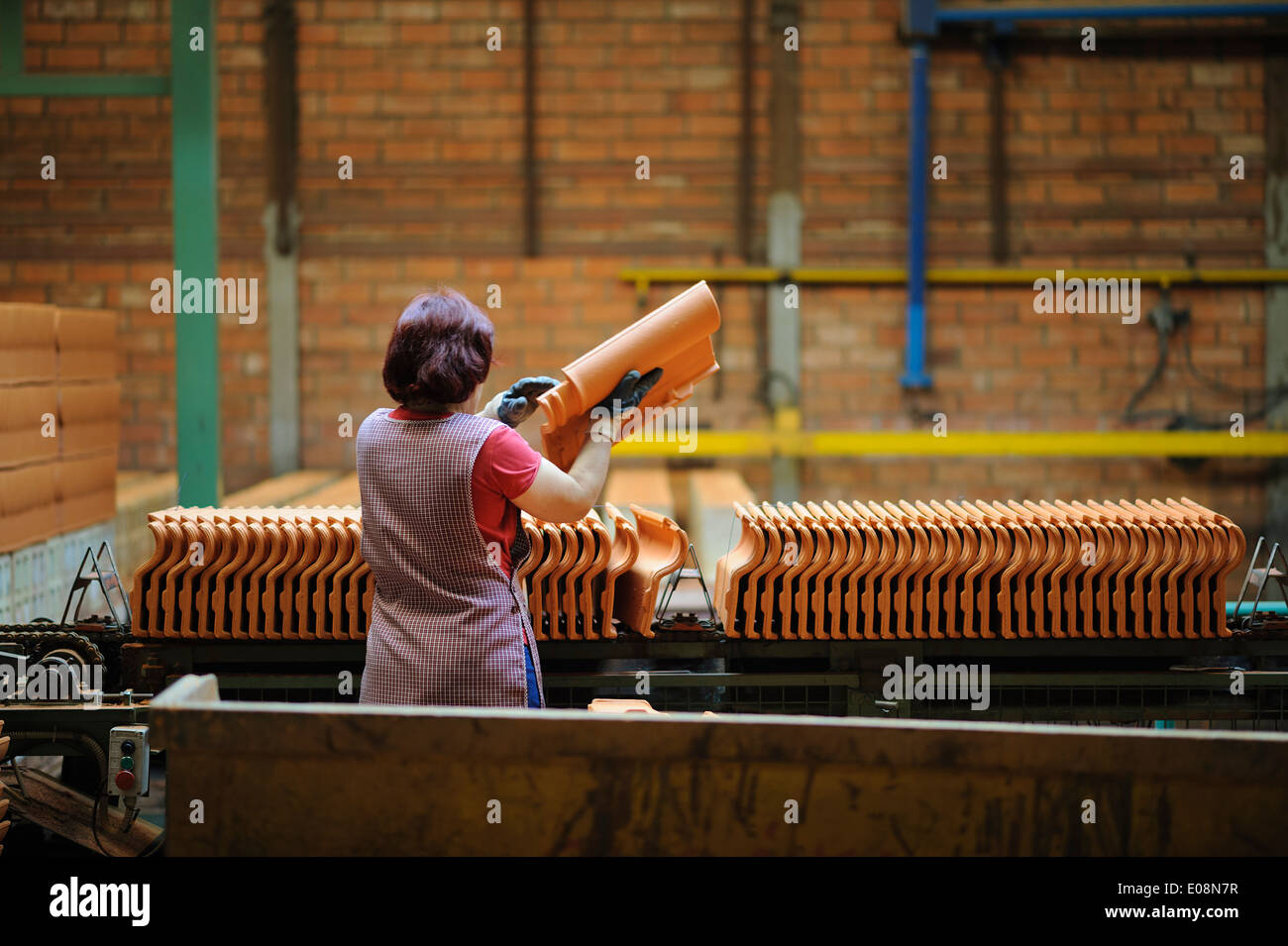 Woman working at clay roof tiles factory Stock Photo