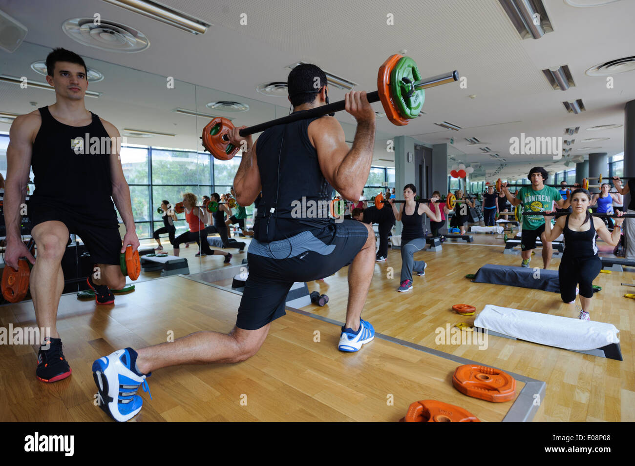 Fitness instructors doing lunge exercises during Body Pump fitness class at the gym Stock Photo