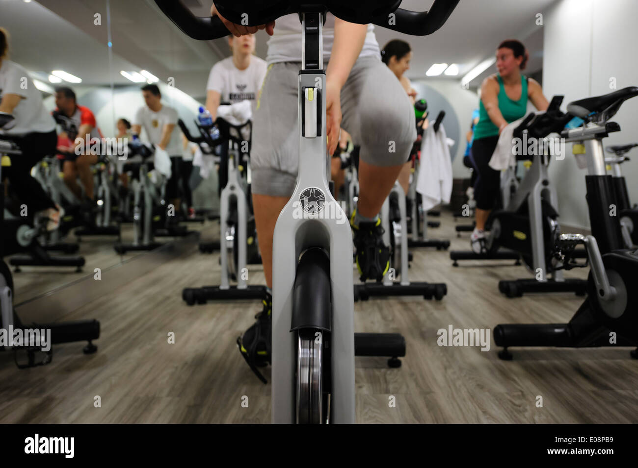 Woman adjusting her stationary bicycle during a spinning class at the gym Stock Photo
