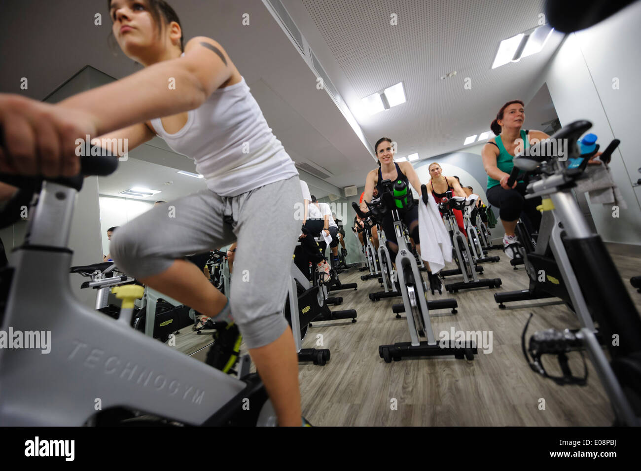 People riding stationary bicycles during a spinning class at the gym Stock Photo
