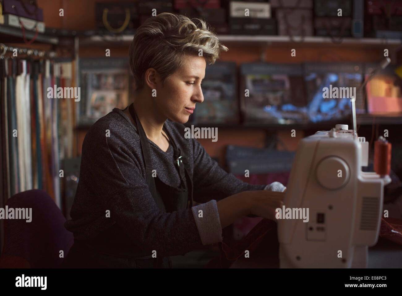 Female fashion designer using sewing machine in studio Stock Photo