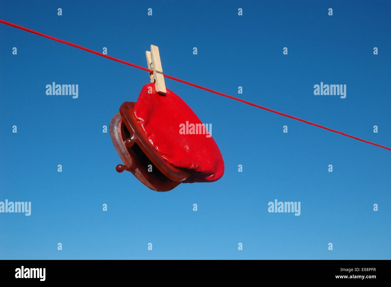 Illustration - A red wallet hangs from a clothes line in Germany, 14 June 2013. Fotoarchiv für Zeitgeschichte - ATTENTION! NO WIRE SERVICE – Stock Photo