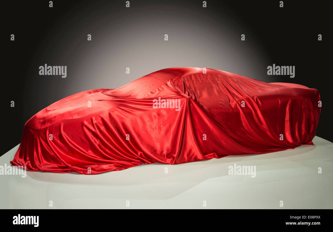 Sports car is covered with a red cloth Stock Photo