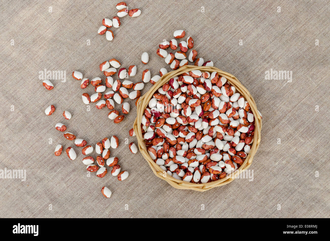 organic white brown beans in wicker basket on linen texture background Stock Photo