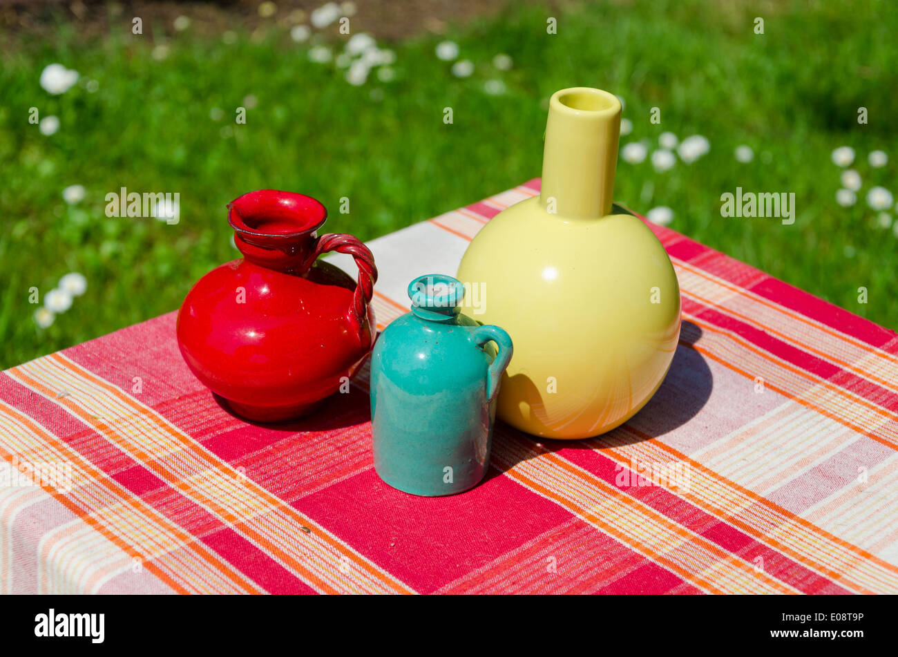 ceramic decorative small colored vase on red striped surface outdoor Stock Photo