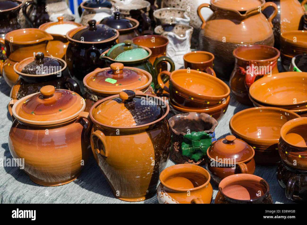 handmade clay pots and cups of various sizes and shapes on fair stall