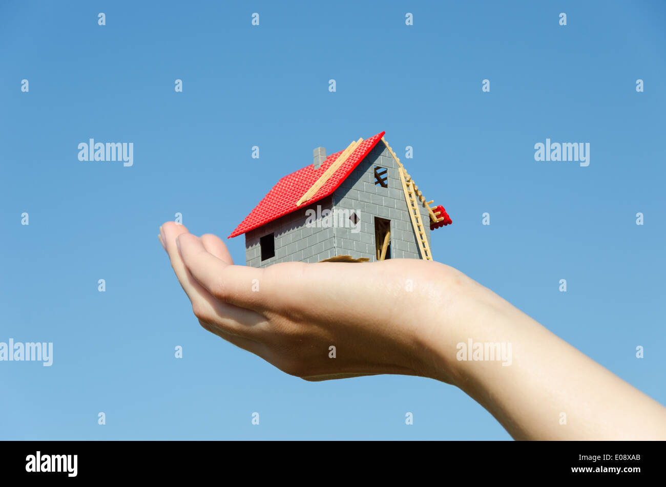 house miniature model in female palm on blue sky background, new house ...