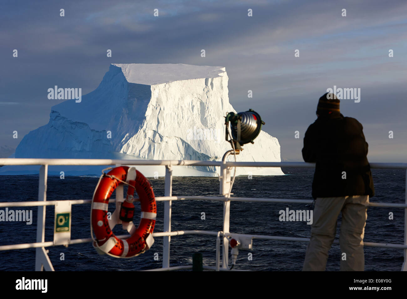 man taking photograph of giant iceberg on board ship in antarctica Stock Photo
