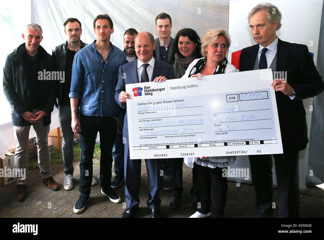 Hamburg, Germany. 06th May, 2014. CEO of Hamburger SV Carl-Edgar Jarchow (R) and Mayor of Hamburg Olaf Scholz (C) hand over a check for over 25,000 euros at Erlensbusch nursing home with HSV head coach Mirko Slomka (L) and HSV players Heiko Westermann (L-R), Rene Adler, Rafael van der Vaart und Marcell Jansen in Hamburg, Germany, 06 May 2014. Erlenbusch is a nursing home for seriously disabled children and is the current support project of the 'Hamburger Weg' (Hamburg Path) and the city of Hamburg. Photo: AXEL HEIMKEN/dpa/Alamy Live News Stock Photo