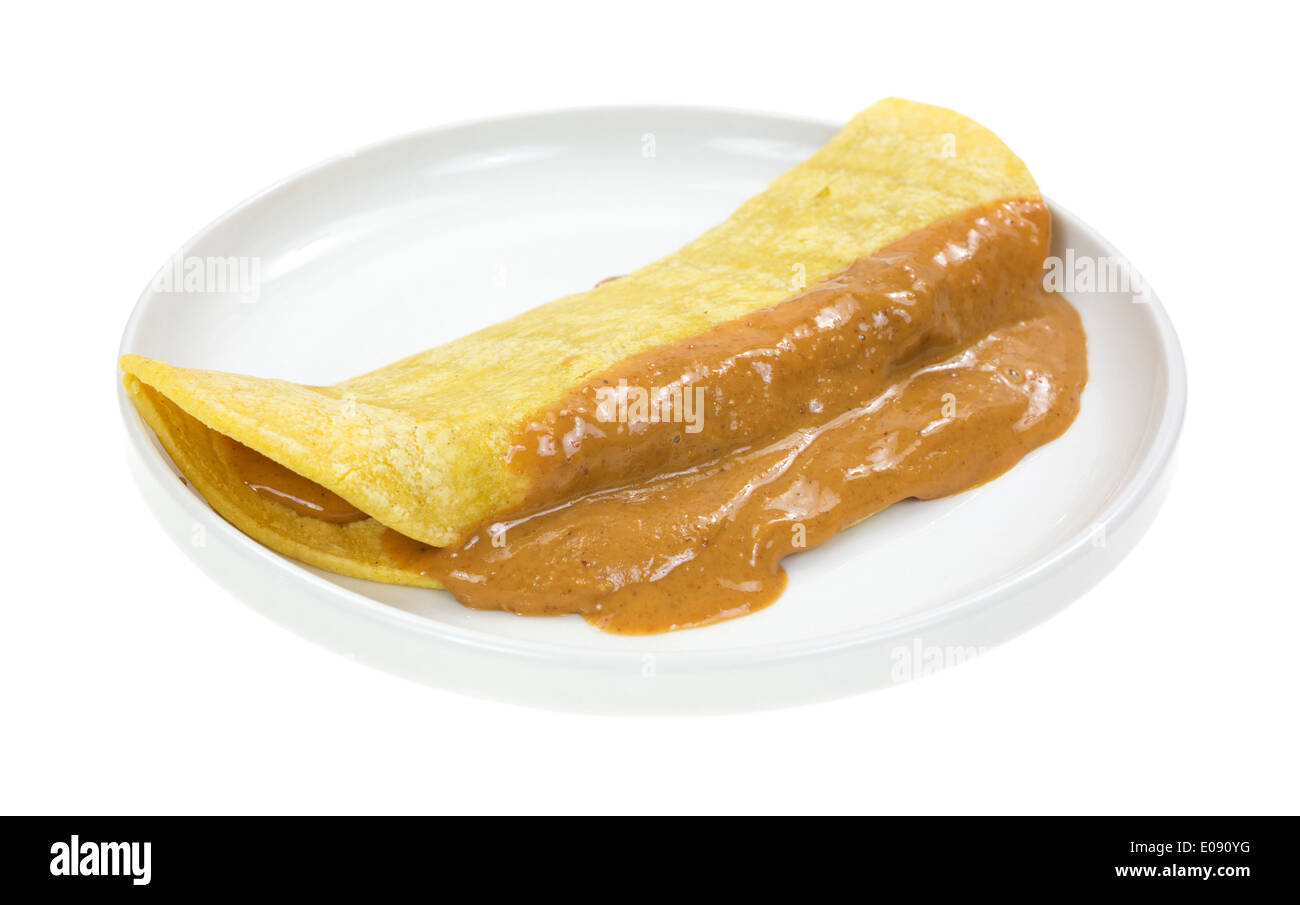 A corn tortilla with melted peanut butter on a small dish. Stock Photo