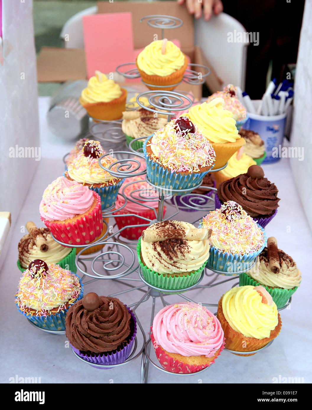 Various cup cakes for sale on a stall at the village carnival at