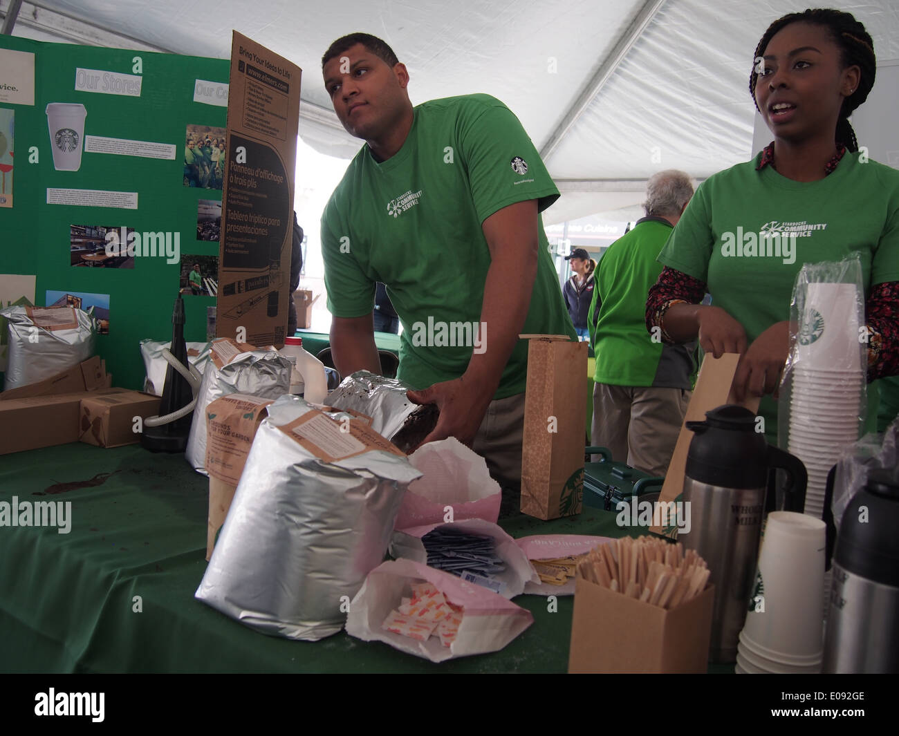 Starbucks reps give out free coffee grinds at an Earth Day festival in