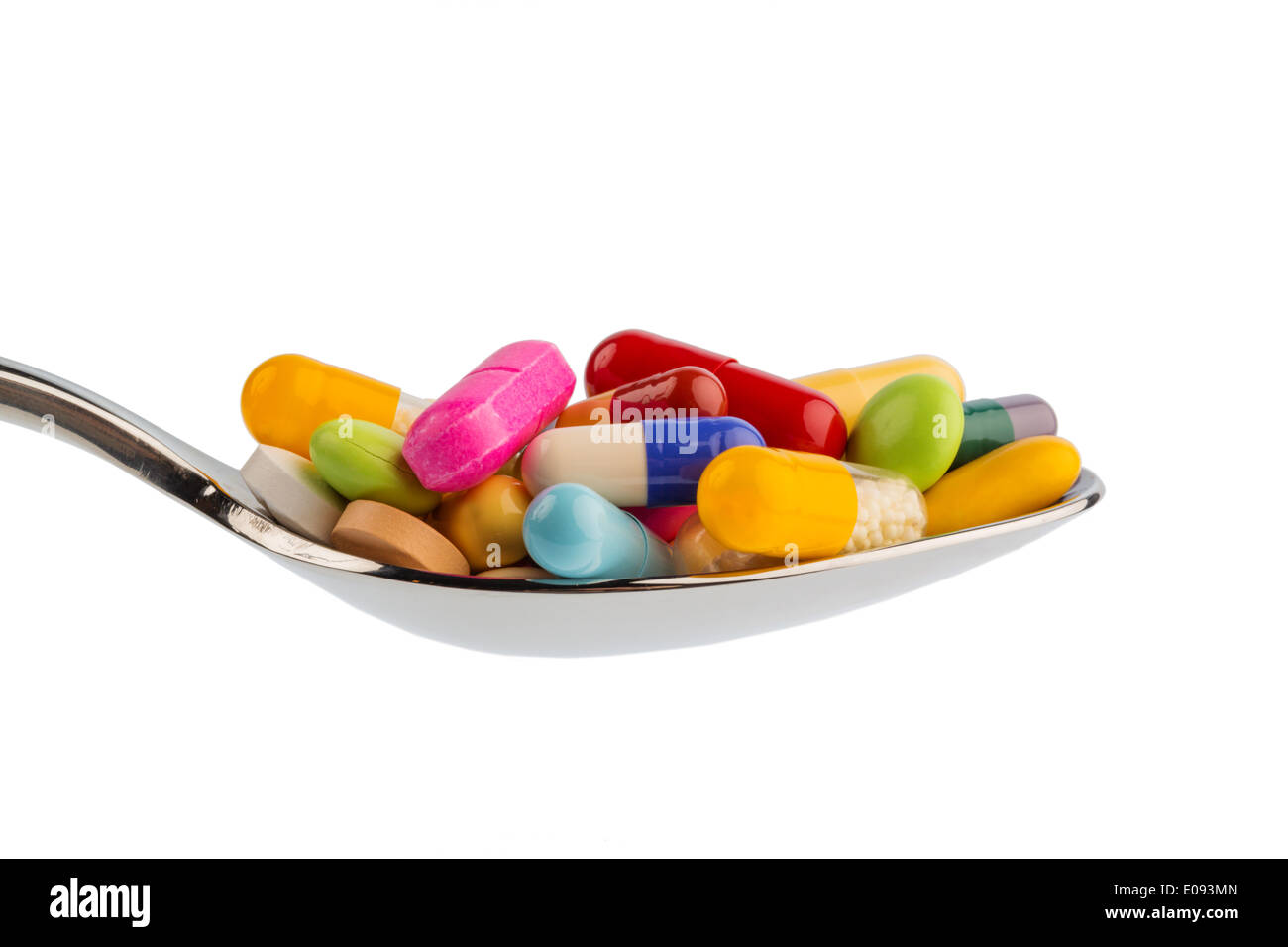 Many coloured tablets on a spoon. Symbolic photo fue tablet addiction and abuse of drugs., Viele bunte Tabletten auf einem Loeff Stock Photo