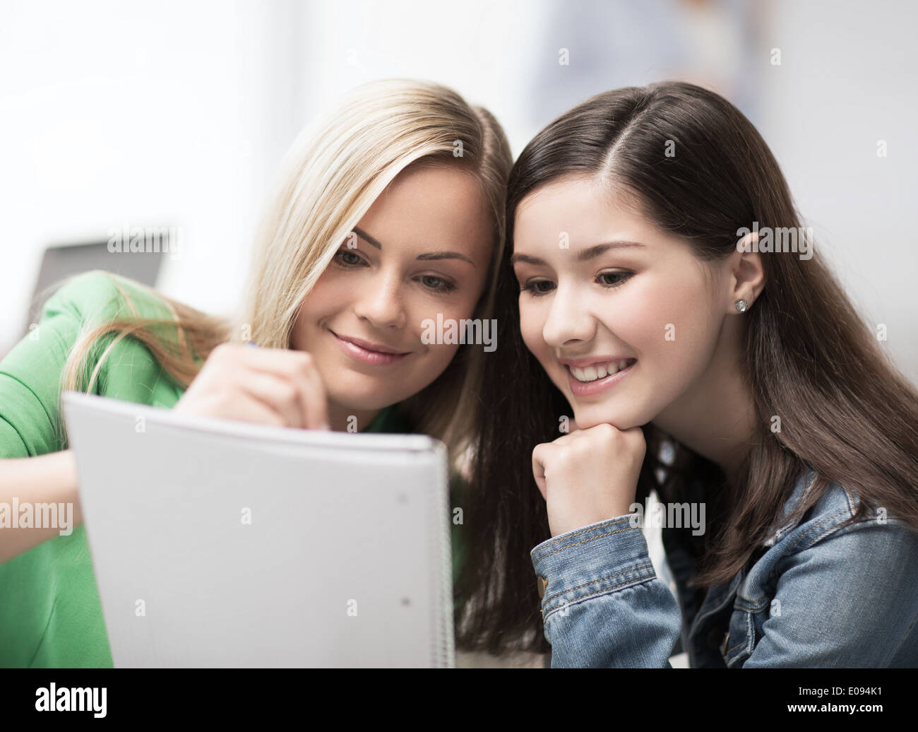 student girls pointing at notebook at school Stock Photo - Alamy