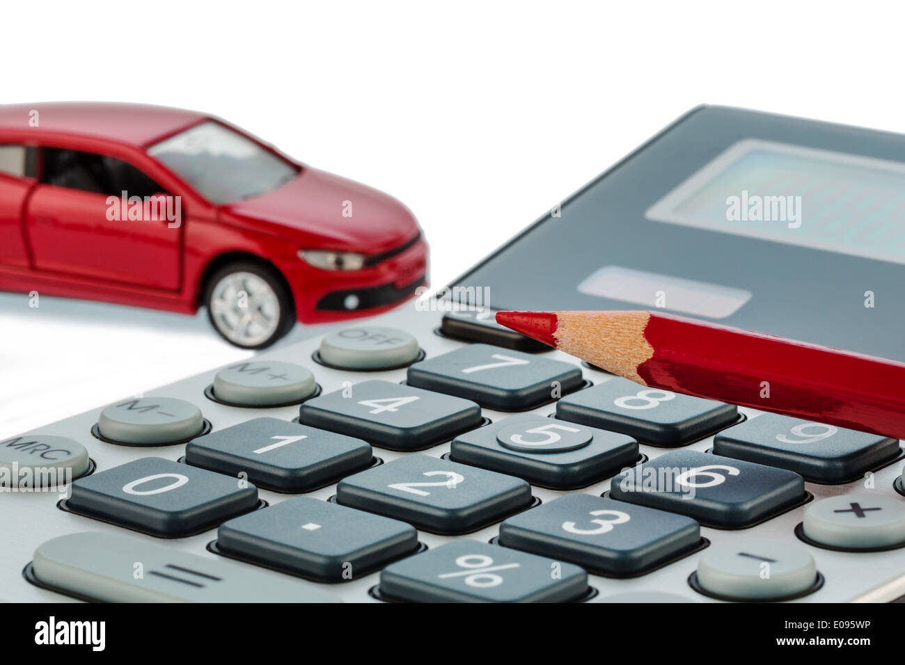 A car and a red pencil lies on a pocket calculator. If cost fue petrol, wear and assurance. Autocosts are not satisfied by commu Stock Photo