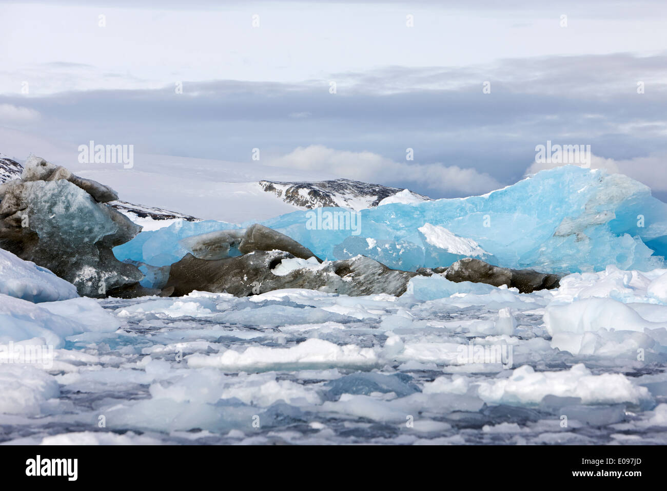 brash sea pack ice forming together with dirty blue iceberg as winter approaches cierva cove Antarctica Stock Photo
