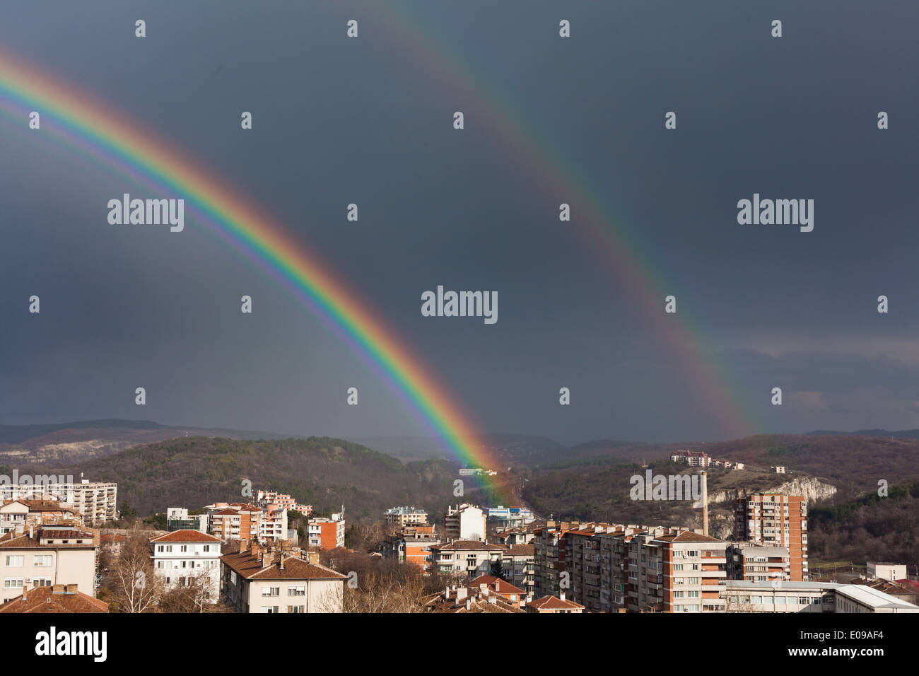 beautiful double full rainbow in blue sky after the rain over city ...