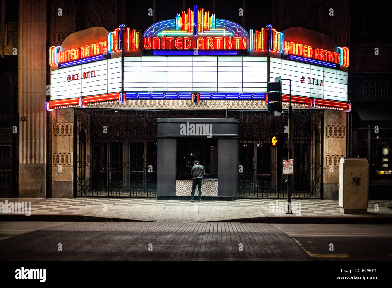A nighttime exposure in front of an illuminated movie theater marquee Stock Photo