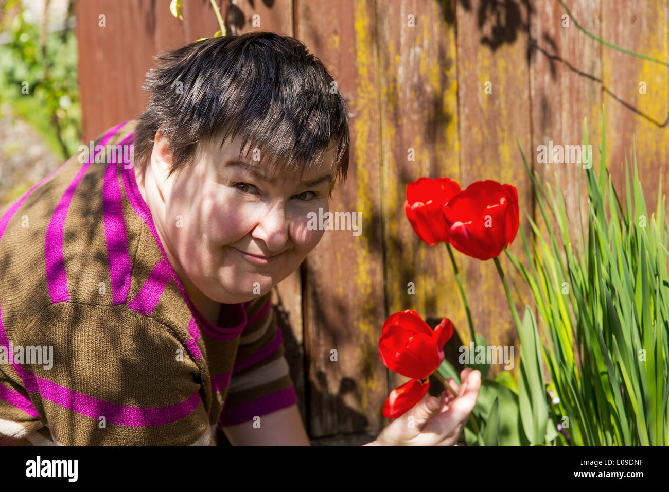 mentally disabled woman smells on a flower Stock Photo