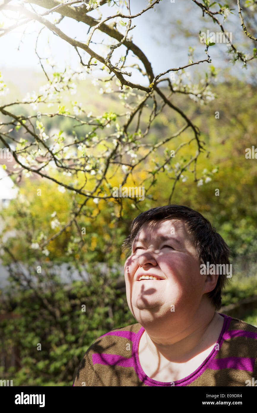 mentally disabled woman under a plum tree Stock Photo