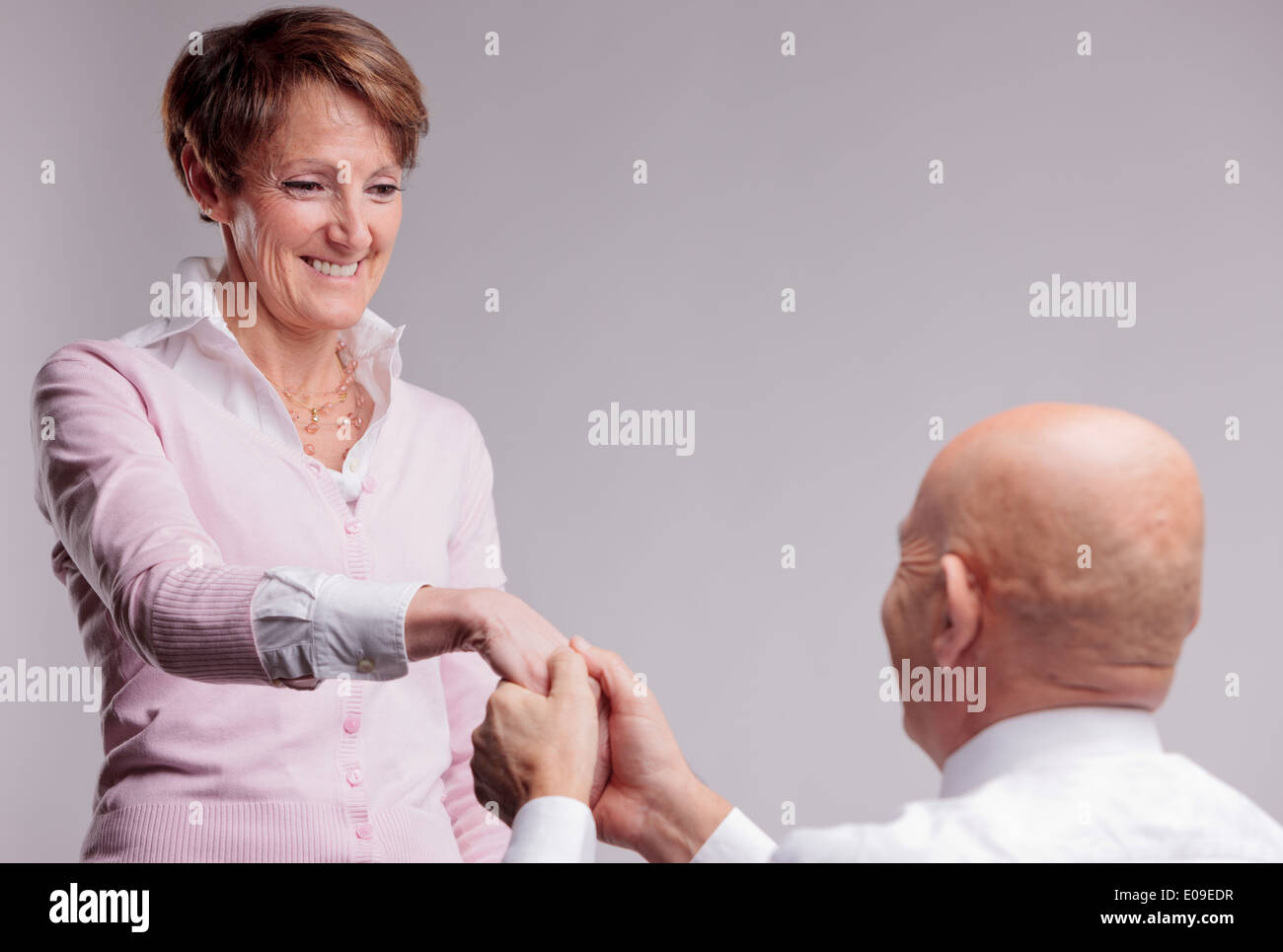 an old man asks an old woman if she wants to marry him Stock Photo