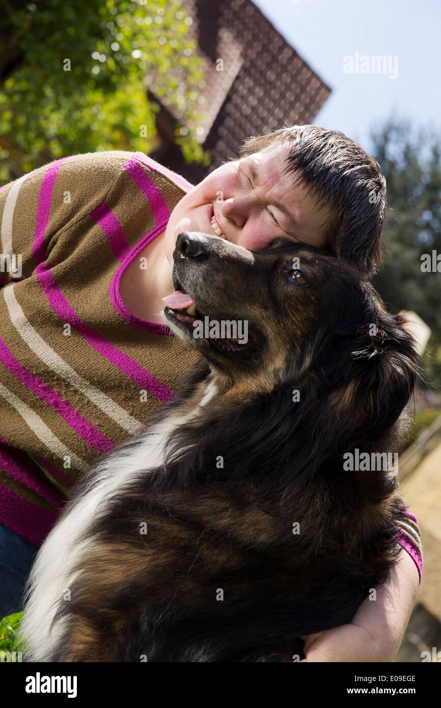 mentally disabled woman cuddles a dog Stock Photo