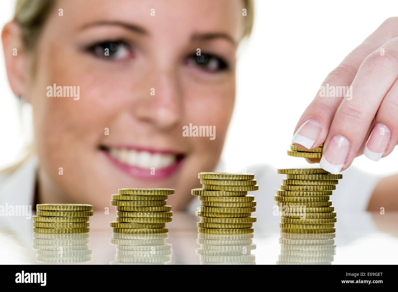 A young woman stacks coins. Symbolic photo fue save, growth, precaution., Eine junge Frau stapelt Muenzen. Symbolfoto fue sparen Stock Photo