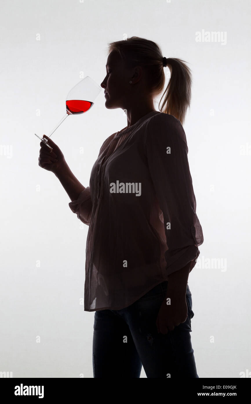 A young woman with a Weinverkostung. If a glass of red wine tries in the red wineglass, Eine junge Frau bei einer Weinverkostung Stock Photo