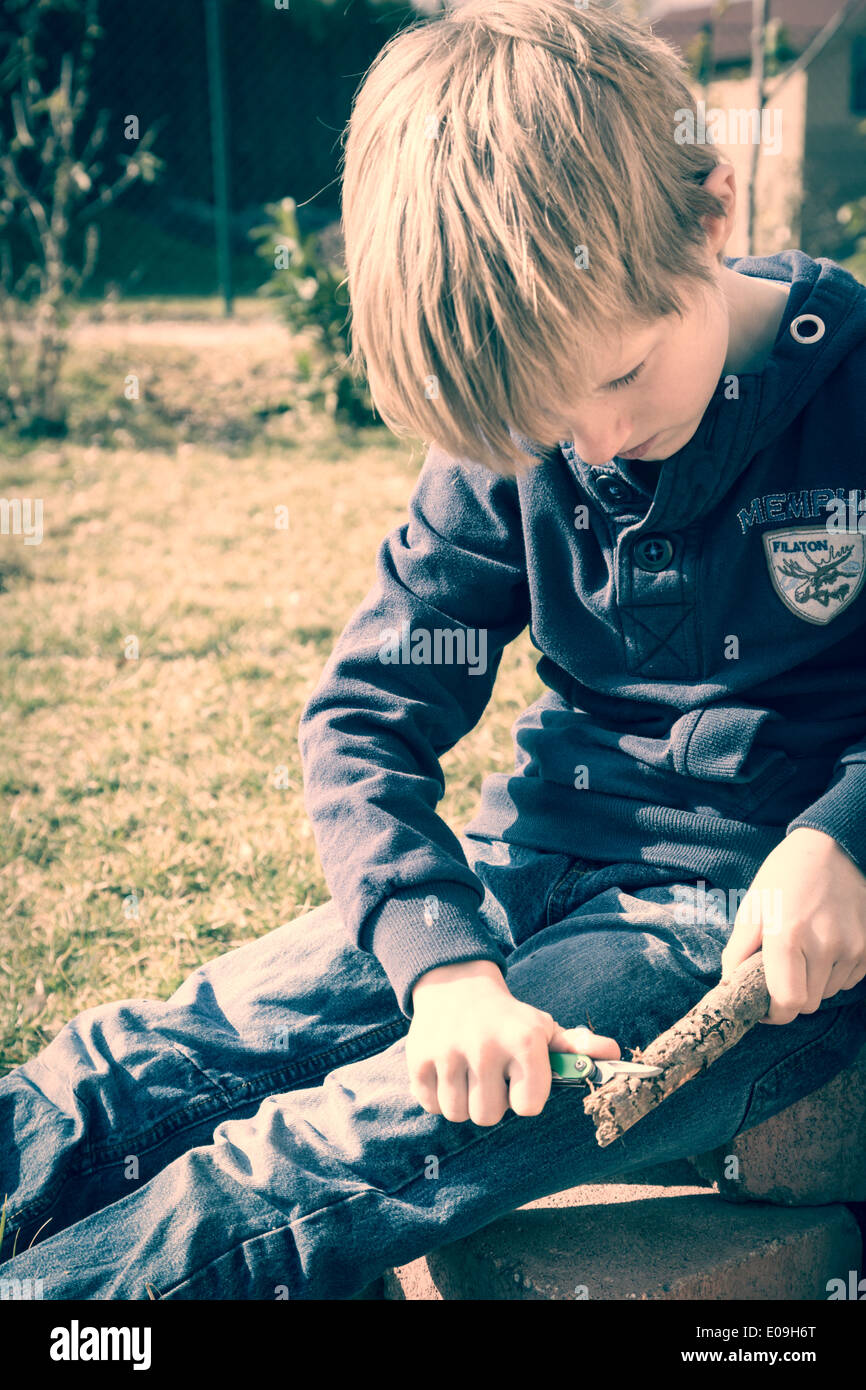 Boy carving wood with pocket knife Stock Photo Alamy