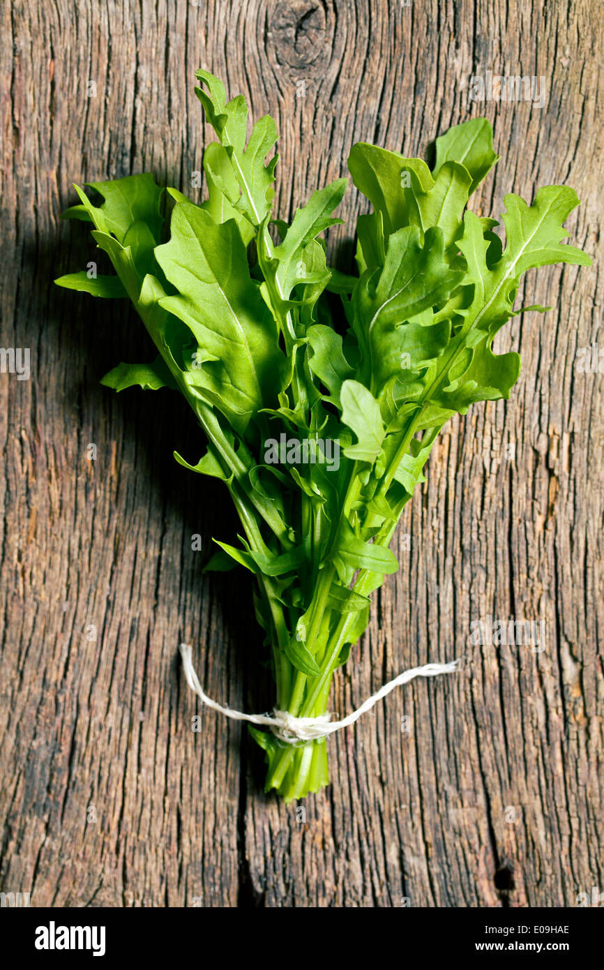 fresh arugula leaves on old wooden table Stock Photo