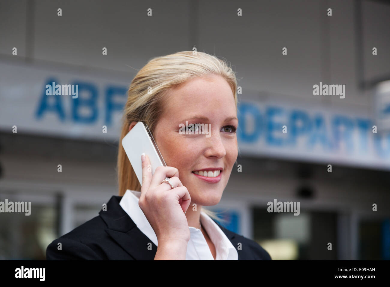 A businesswoman calls up her mobile phone at the airport. Roaminggebuehen by smartphones abroad, Eine Geschaeftsfrau telefoniert Stock Photo