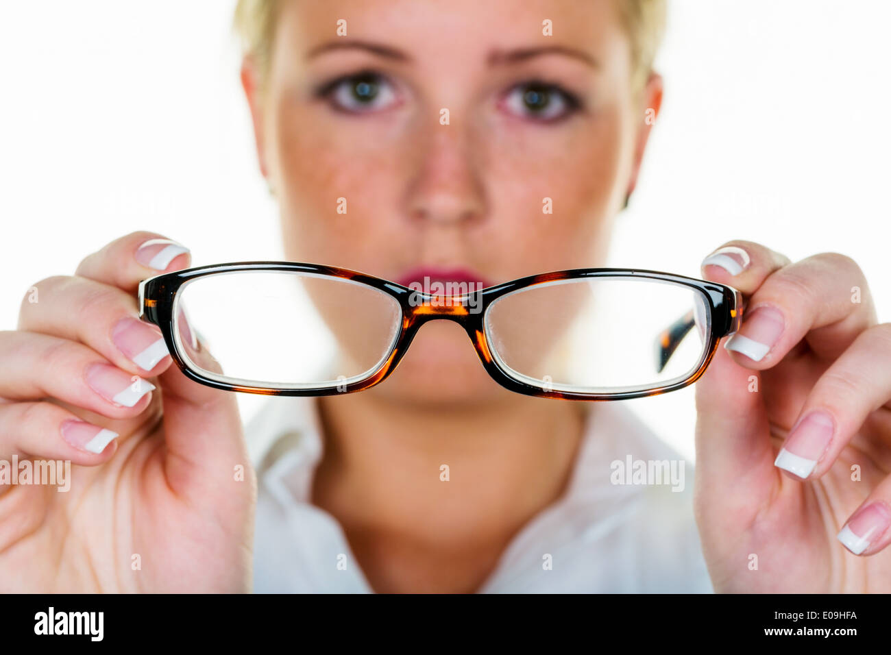 A woman holds glasses in the hand. Symbolic photo fue bad seeing and defective vision, Eine Frau haelt eine Brille in der Hand. Stock Photo