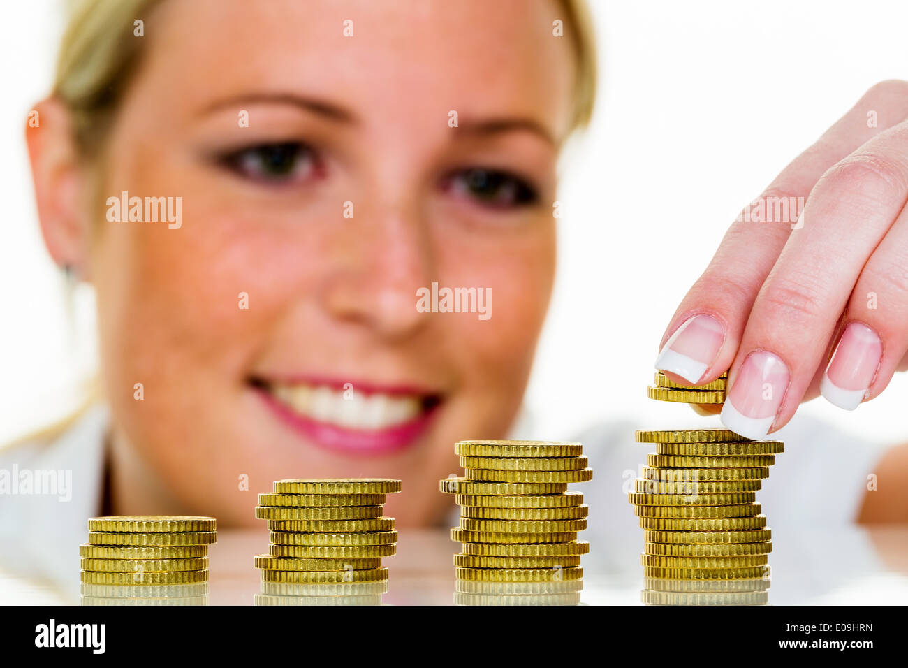 A woman stacks coins. Money save fue the future., Eine Frau stapelt Muenzen. Geld sparen fue die Zukunft. Stock Photo