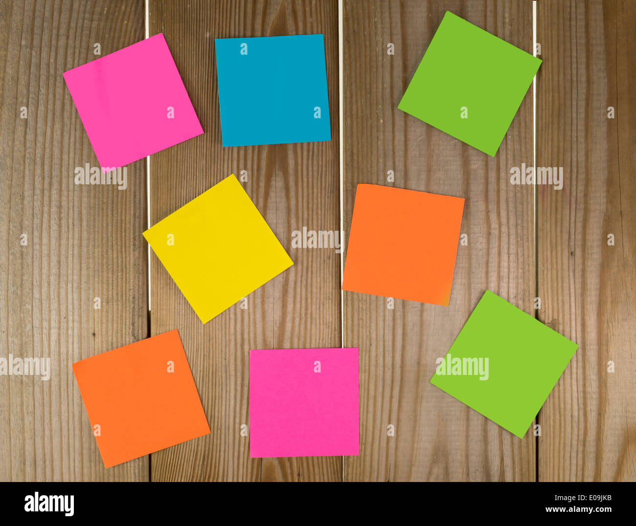wooden wall with papers in green yellow blue pink and orange Stock Photo