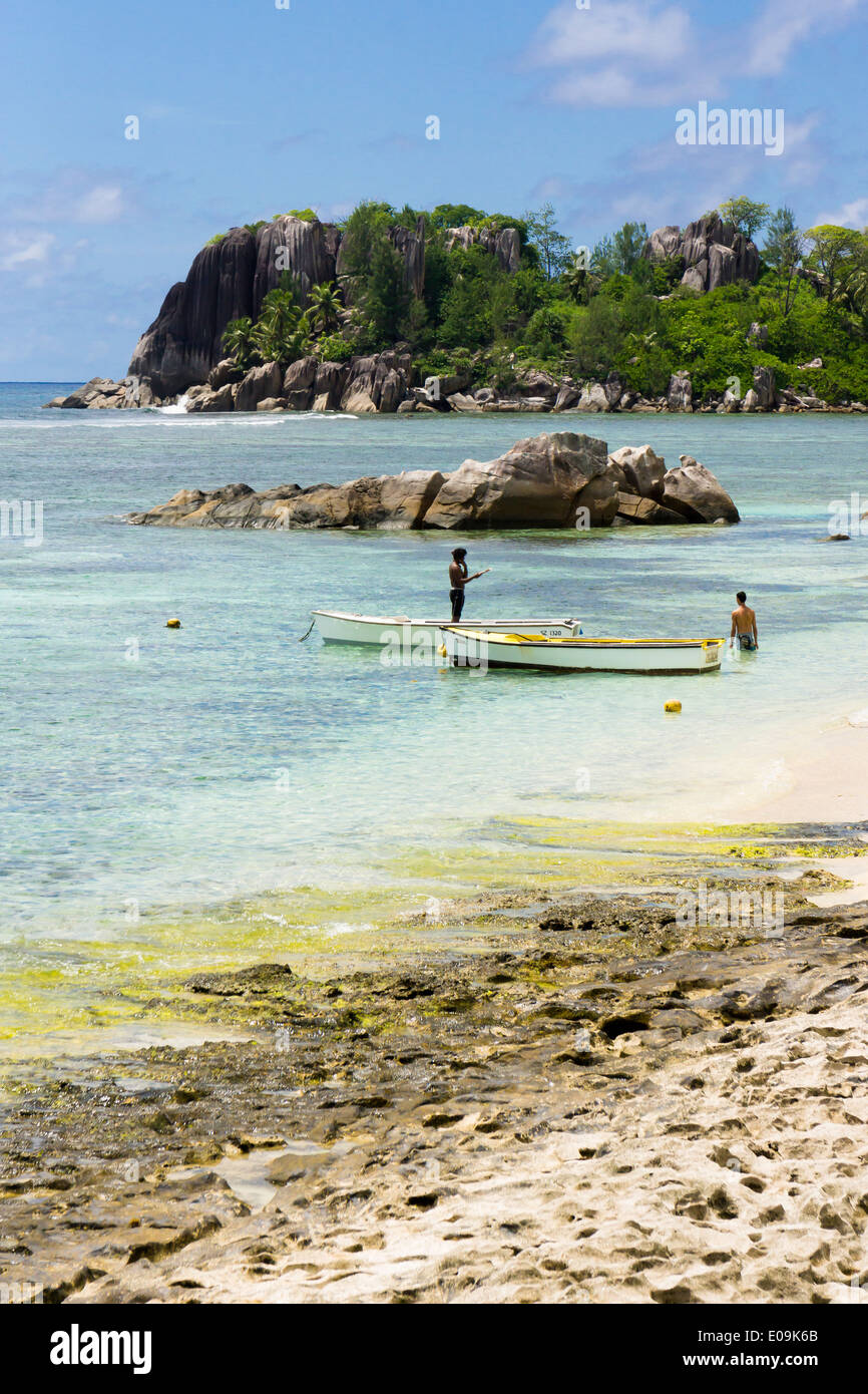 Seychelles, Mahe, L'Islette, boats and two people at beach Stock Photo