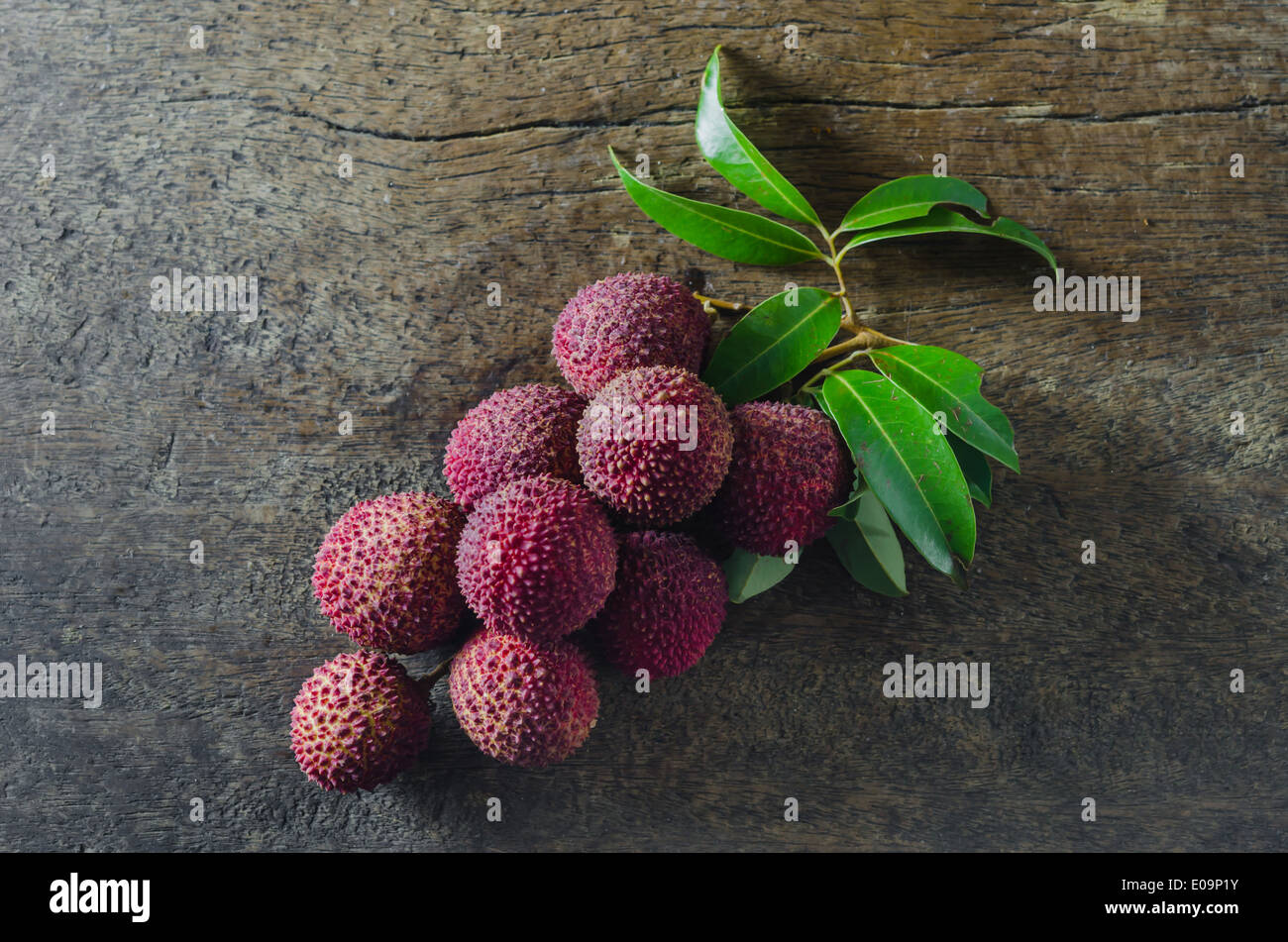 Lychee with leaves on a wooden table Stock Photo