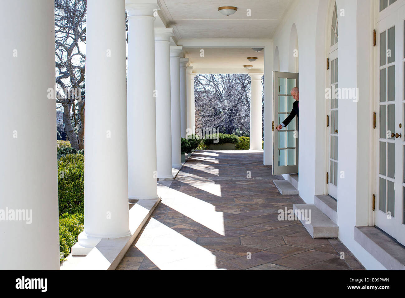 US Vice President Joe Biden opens a door from the Outer Oval Office onto the Colonnade of the White House on his way to a National Governors Association meeting February 24, 2014 in Washington, DC. Stock Photo
