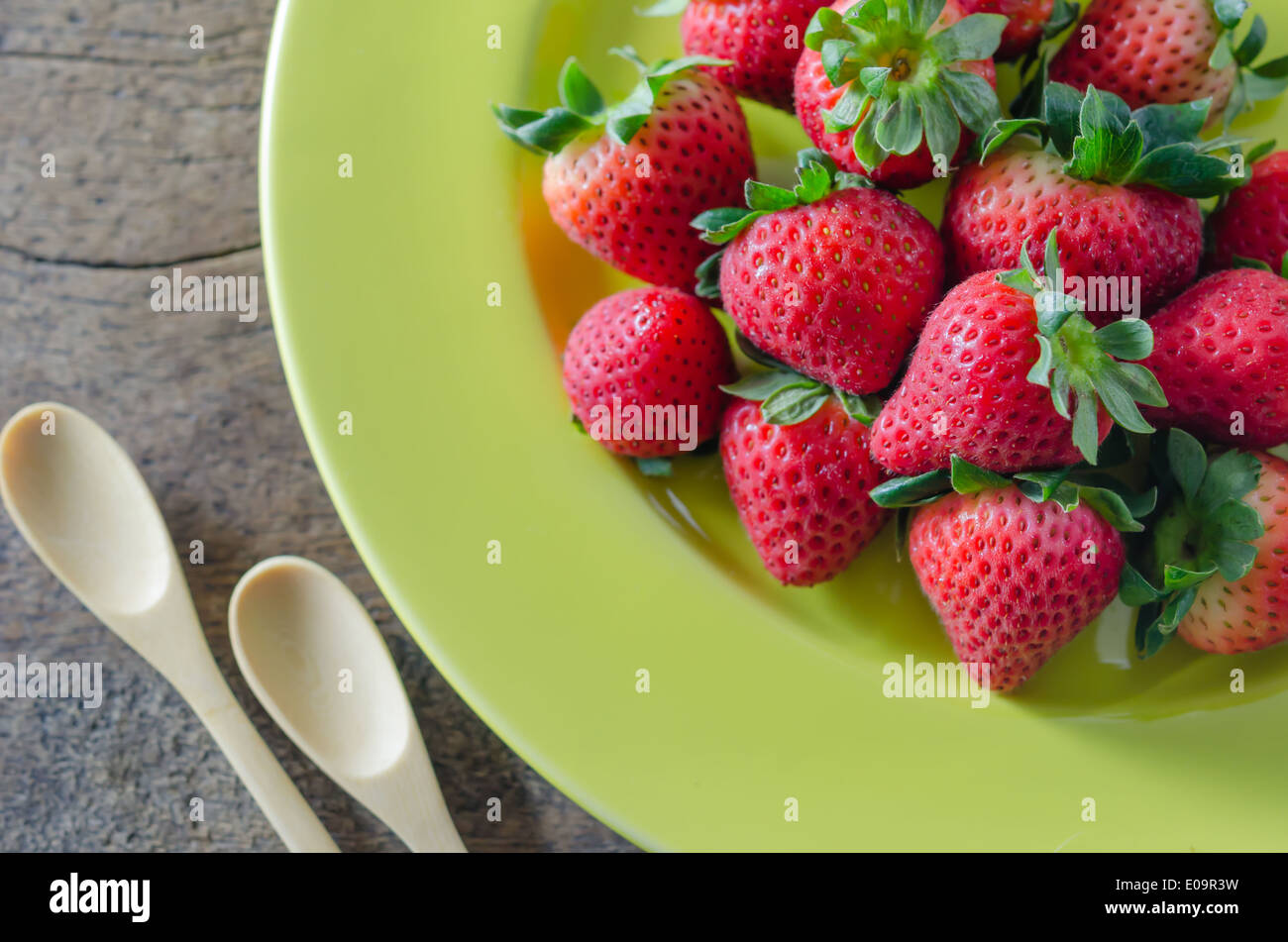 still life of fresh red strawberries on dish over wooden background ...