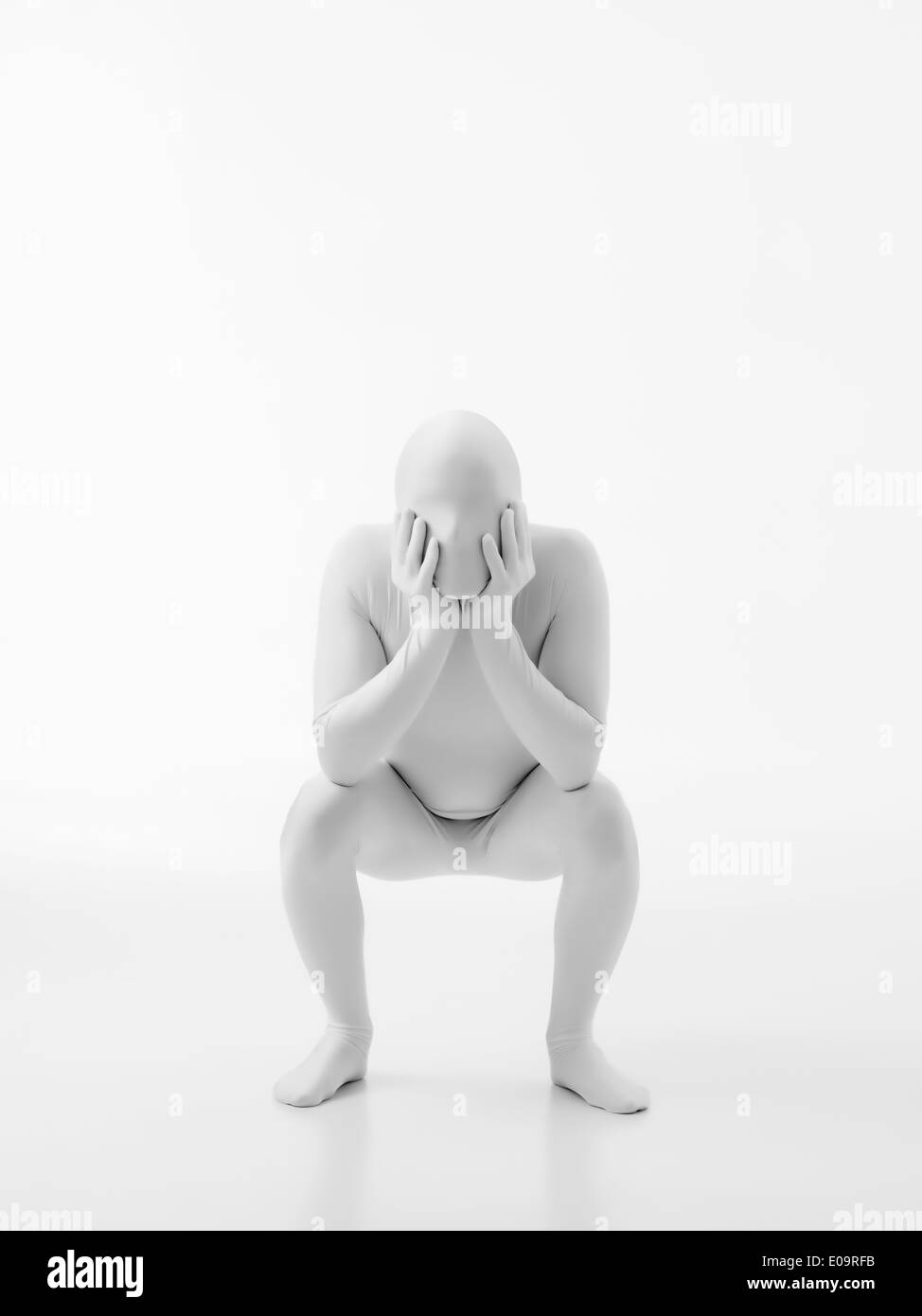 faceless man dressed in white with hands on his cheeks sits in a seat ...