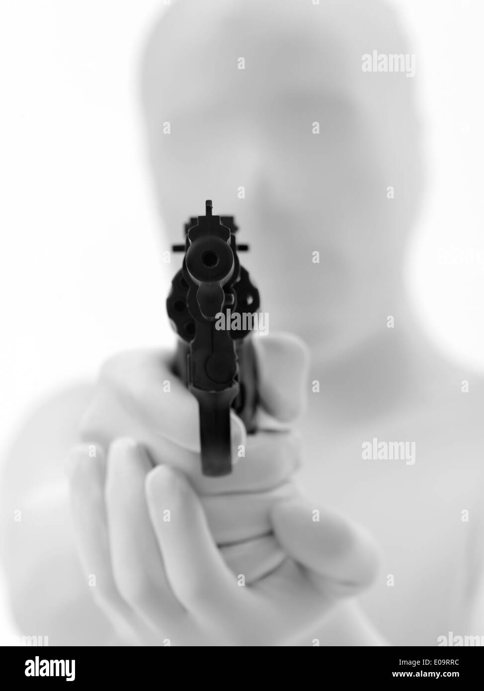 faceless man dressed in white aims gun at you Stock Photo