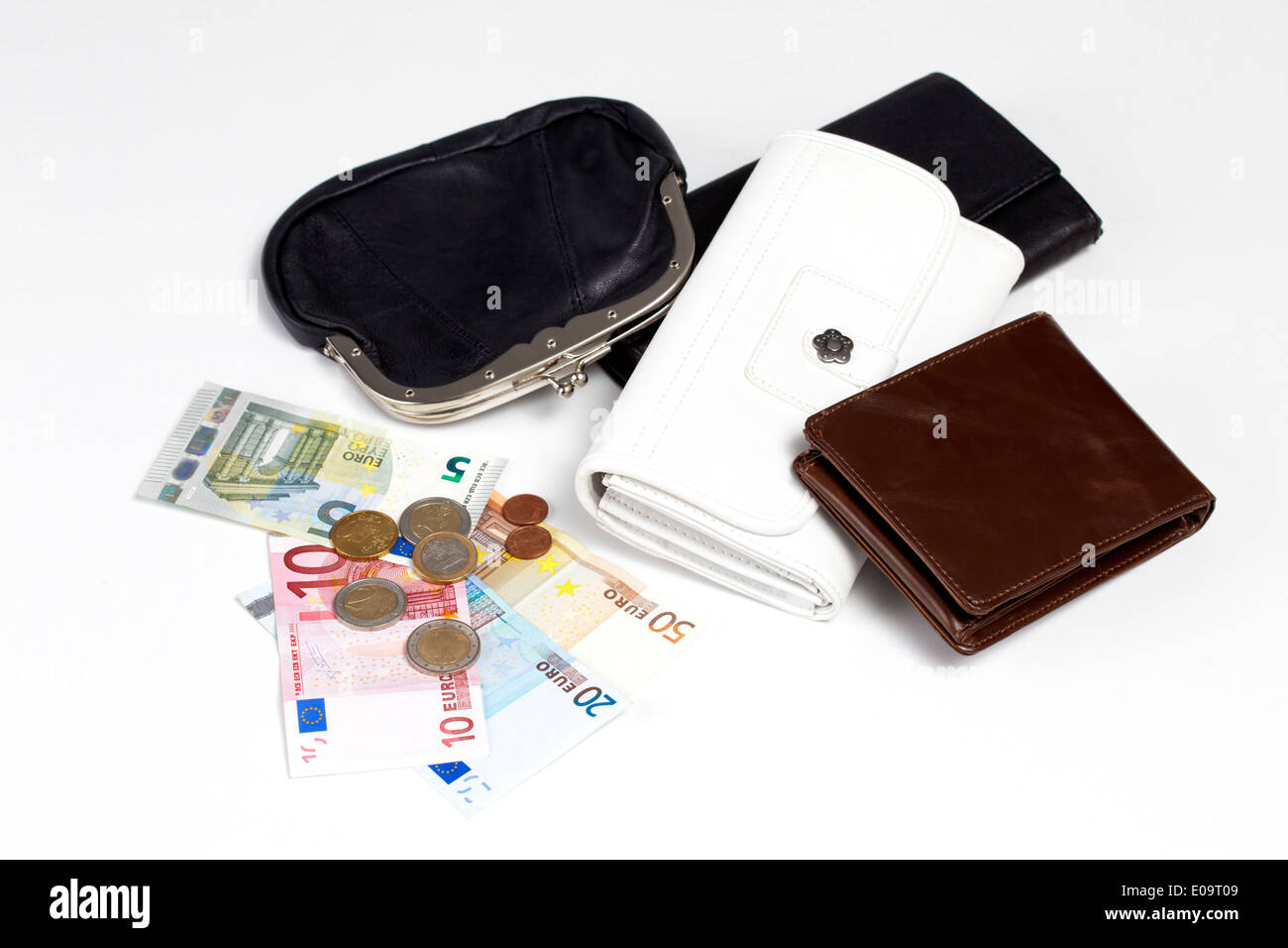 Different purses, banknotes and coins on white ground Stock Photo