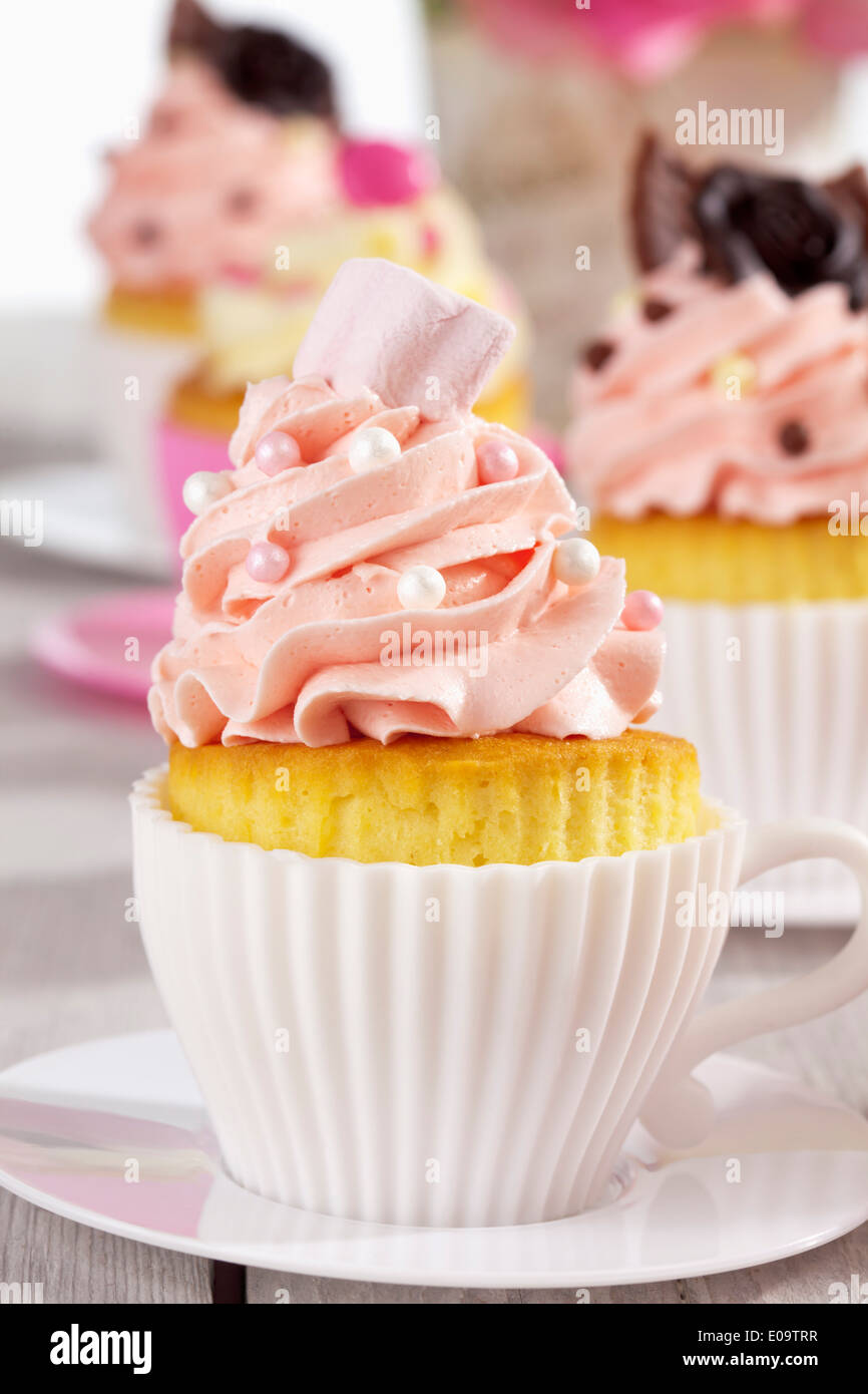 Baking dishes formed like cups with decorated cupcakes Stock Photo Alamy
