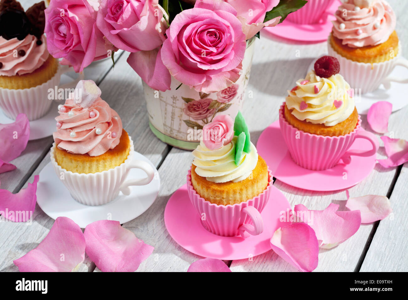 Cupcakes And Flower Vase Of Pink Roses On Wooden Table Stock Photo