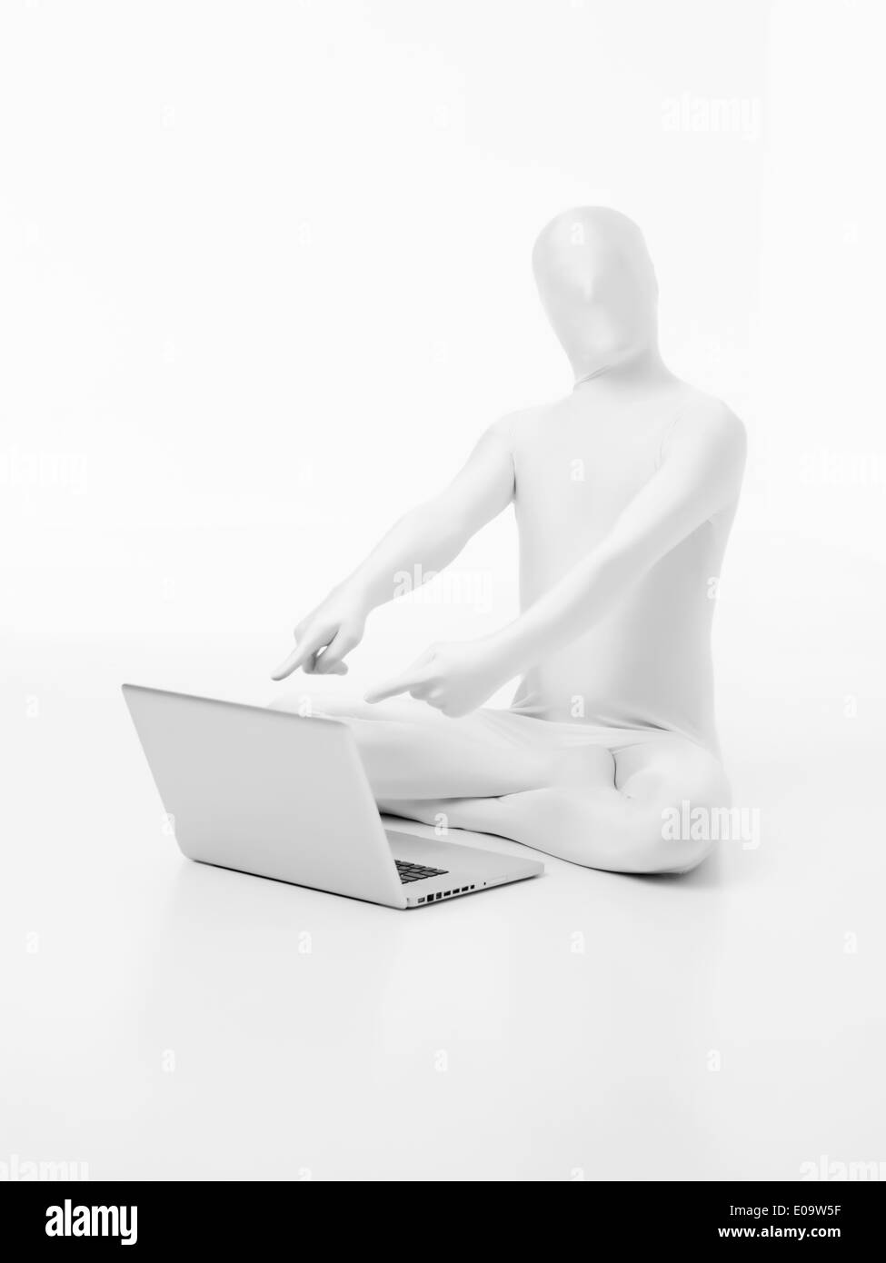 faceless man dressed in white sitting on the floor with laptop pointing ...