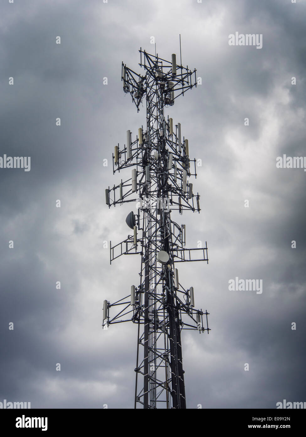 Mobile phone antenna tower against a dark stormy sky Stock Photo